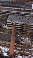 Old industrial zone with ruined buildings. Empty abandoned factory with brick edifices in place. Large aged enterprise. Top view. Vertical video