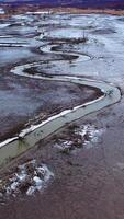 Narrow dirty river. Ecological problems with water. Dried place with a stream with muddy water floating in the countryside. Aerial view. Vertical video