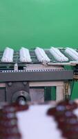 Automated line for production sweet desserts at food factory. Conveyor belts with white marshmallows and those covered with chocolate. Vertical video