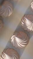 Beautiful creamy vanilla marshmallows come from a machine. Conveyor belt with fresh zephyr desserts. Close up. Top view. Vertical video