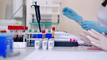 laboratório técnico segurando sangue tubo amostra para estudar. médico tecnólogo caindo sangue para dentro teste tubo dentro hospital laboratório video