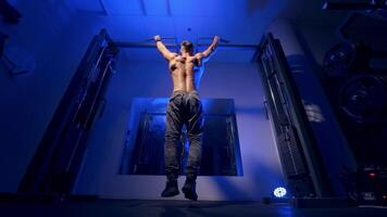 Bodybuilder pulling up on horizontal bar. Athlete muscular fitness male pulling up on horizontal bar in gym video