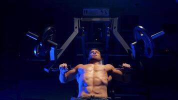 Bodybuilder working out in gym. Strong man during exercise with work out program for healthy video
