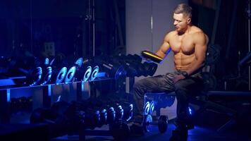 Man spending time in gym. Bodybuilder having rest after heavy deadlifts in modern fitness center video