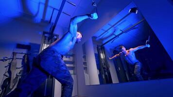 Man in gym working out. Handsome bodybuilder works out pushing up excercise in gym in front of the mirror video