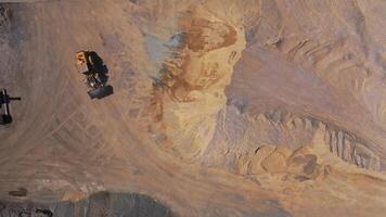 Excavator working on sandy surface. Aerial top view of heavy earthmover working at construction site video