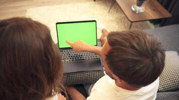 A couple sitting on a carpet, browsing an online store. Top view, chromakey. video