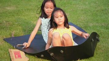 Children are playing on a slide on a grassy hill in a park. Happy active kids playing outdoors during the summer. video