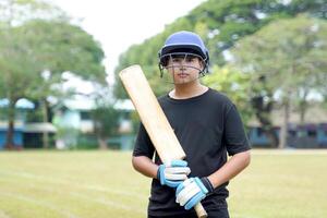 Clicket players hold bats in hand while practicing on the field. Soft and selective focus. photo