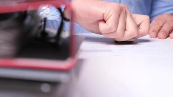 Hand stamps a document on a desk in an office, showing professionalism and dedication in paperwork. Office worker stamping a document with wooden stamper video