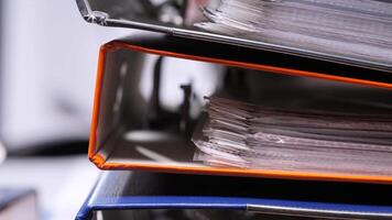 close-up Stack of colorful office binders overflowing with paperwork. Overflowing office binders stacked high, suggesting a busy administrative environment with a focus on organization video