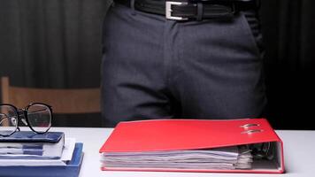 Boss gives an assignment to an office worker. Overload of work in the office. Archive of documents in binder folders. men stack folders with documents on the desk. Concept of document archive video