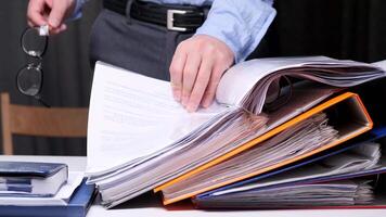 close-up of a lawyer leafing through the materials of a client's case. Concept of a large amount of paperwork. Office routine work. An office worker opened a binder folder with documents video