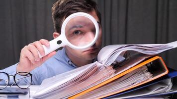 accountant scrutinizing paperwork with a magnifying glass, highlighting detailed financial analysis and auditing processe. portrait office worker. Careful examination of documents. Investigation video
