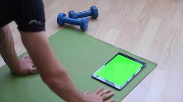 A man is using a tablet with a green screen, ideal for digital work, content creation, E-commerce, and showcasing technology, perfect for online tasks, marketing campaigns, and creative projects video