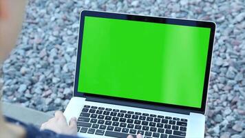A person using a laptop with a green screen, perfect for digital work, content creation, E-commerce, and remote work. Ideal for showcasing technology, online tasks, and digital marketing projects video