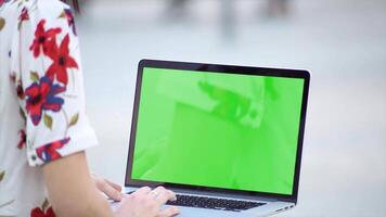 A woman using a laptop with a green screen, ideal for digital work, E-commerce, content creation, and remote work. Perfect for showcasing technology, online tasks, and digital marketing projects video