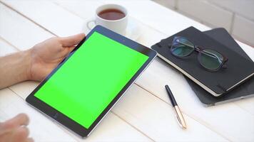 A man using a tablet with a green screen on the table perfect for digital content creation and Ecommerce video