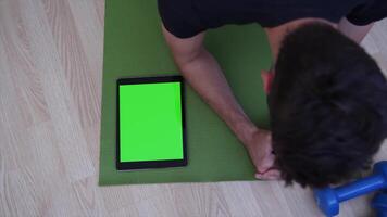 A man is sitting on the floor with a tablet computer, perfect for digital work, creative projects, and online tasks. Ideal for showcasing modern technology, remote work, and comfortable workspaces. video