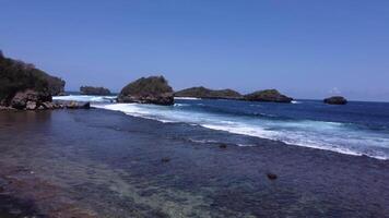 The atmosphere of the waves and small islands on the tropical beach, precisely in Peh Pulo, East Java, Indonesia video