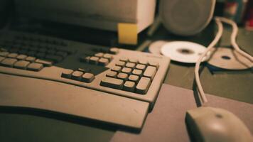 Old computer equipment on a cluttered desk with faded colors in soft lighting video