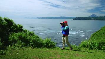 Happy Man Traveling Alone In Mountains, Admiring Scenery From Top And Photographing Seascapes video