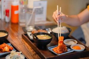 Woman hand holding chopsticks for eating Kimchi salad in restaurant. Japan food traditional Kimchi photo