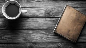 cozy workspace featuring cup of coffee beside leather bound notebook on rustic wooden table. This setup invites creativity and productivity photo