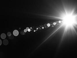 Bright light beams create stunning visual effect with soft bokeh and lens flare, enhancing dramatic contrast against dark background photo