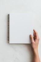 blank sketchbook held by hand, perfect for artists and creatives to express their ideas. This image captures essence of creativity and inspiration photo