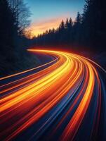 winding road illuminated by vibrant light trails at sunset, surrounded by trees. scene captures dynamic movement and beauty of nature photo