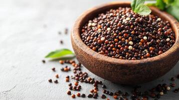 Quinoa seeds in wooden bowl on textured surface, showcasing their diverse colors and textures. This nutritious superfood is perfect for healthy meals photo