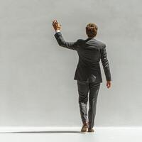 Businessman in suit waving goodbye, showcasing confidence and professionalism. clean background emphasizes subject posture and attire photo