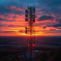 Stunning telecommunications tower silhouetted against vibrant sunset, showcasing blend of technology and nature beauty photo