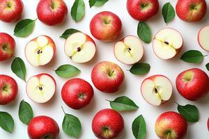 Freshly sliced apples with glossy red skin and green leaves create vibrant display. contrast of juicy white flesh against bright red skin is visually appealing photo