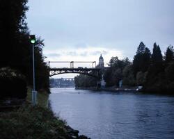 Serene Lakeside Scene with a Girder Bridge Under Cloudy Skies photo