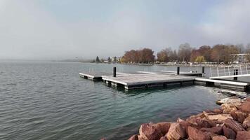 A serene lakeside pier on a misty autumn day, perfect for relaxation and fall getaways video