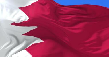 Bahraini flag waving at wind in slow with blue sky, loop video