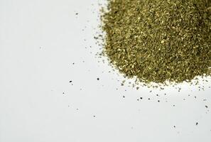 Dry ocha or green tea organic beverage leaves isolated on horizontal empty copy spaced white background. photo