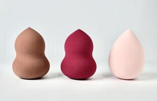 Three curvy and tear drop make up tool soft beauty blender sponge set isolated on horizontal white background. photo