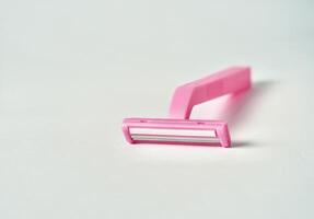One pink colored razor tool object isolated on horizontal ratio copy spaced white background. photo