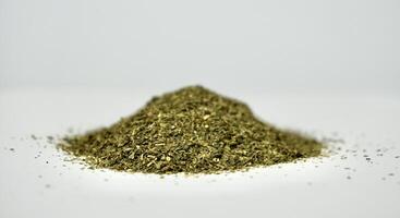 Pile of dry ocha or green tea organic beverage leaves isolated on horizontal white background. photo