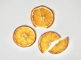 Dried orange fruit slices with different shapes isolated on horizontal white background from above angle view. photo