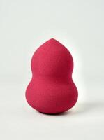 One pink red make up tool soft beauty blender sponge isolated on vertical white background. photo