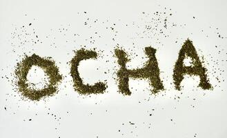 Ocha word alphabet letter shapes from dry ocha or green tea organic beverage leaves element isolated on horizontal white background. photo