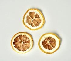 Three dry lemon citrus slices isolated on horizontal white background from above angle view. photo