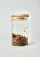 Beef meat floss or abon sapi in round transparent glass jar container isolated on vertical white background. photo