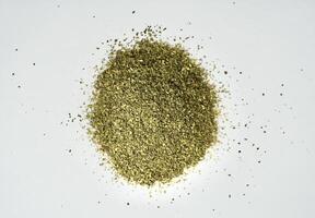 Dry scattered ocha or green tea organic beverage leaves isolated on horizontal white background from above angle view. photo