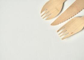 Bamboo wooden kitchenware eating utensil spork, fork, and knife objects isolated on horizontal ratio copy spaced empty white background. photo