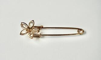 One rusty metal brooch with flower shape design isolated on horizontal white background. photo